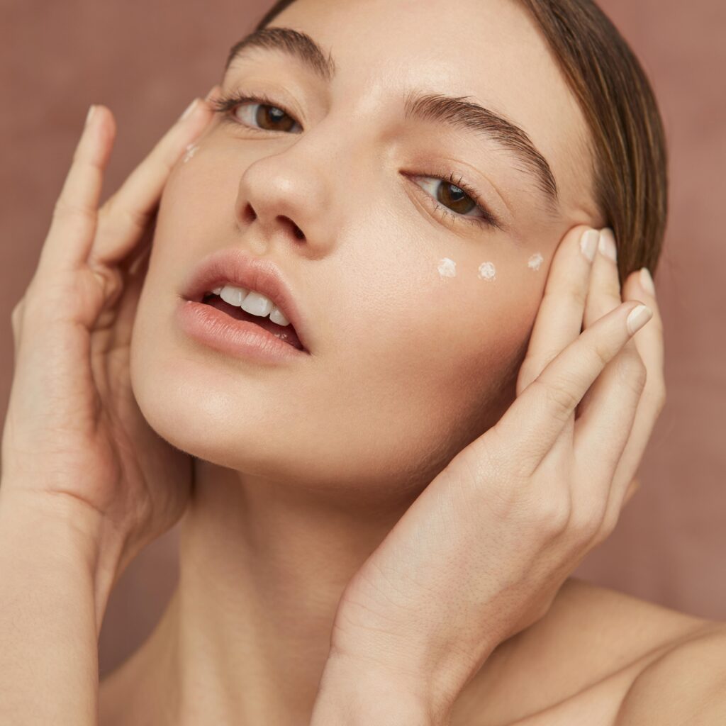 woman posing with face cream close up
